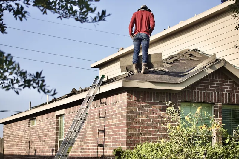 Professional roofer working on a residential roof in Roslyn Harbor